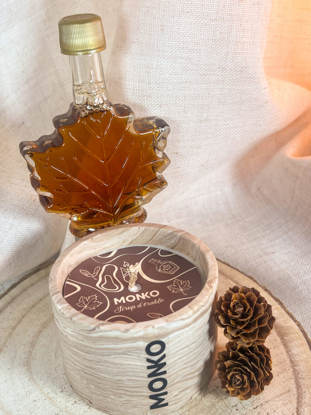 Bougie 120g au parfum de sirop d'érable sur un rondin de bois, la photo est rapproché sur le dessus